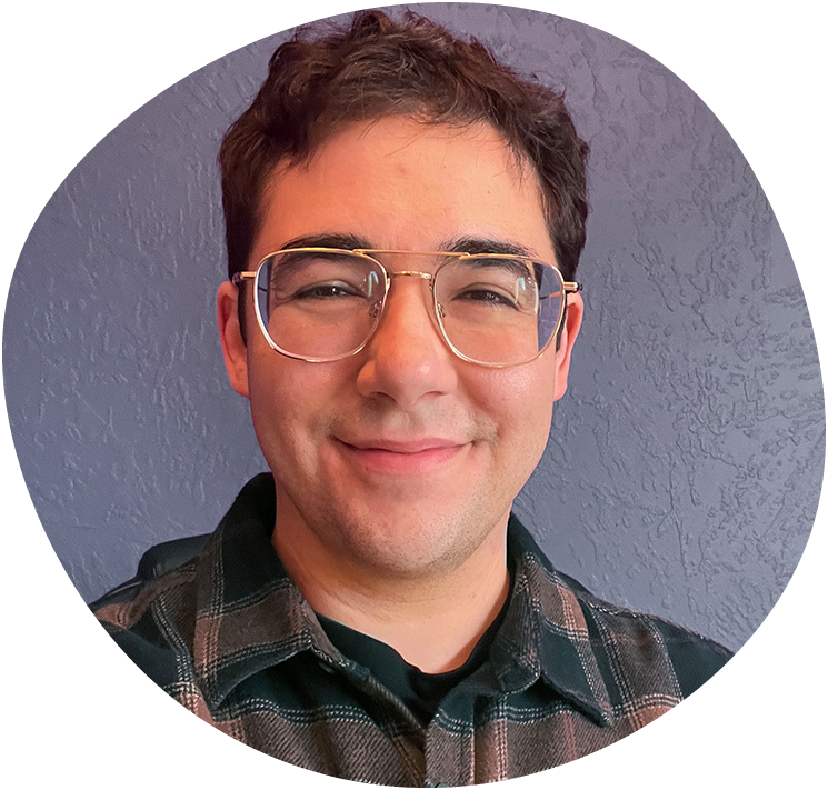 austin-blob A smiling person (Austin) with glasses wearing a plaid shirt.